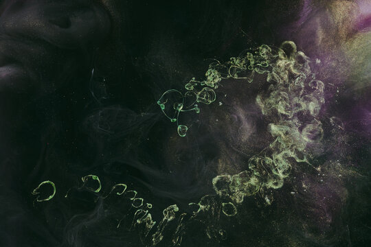 Abstract colorful green smoke on black background. Moving flow of paints, fluid liquid art, space sky