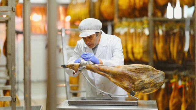 Male worker places jamon on jamonero to cut it into appetizing pieces. Ham factory. High quality 4k footage