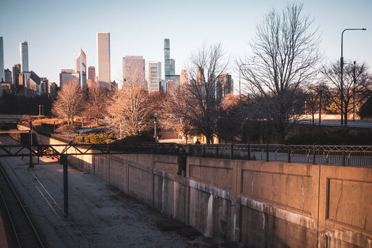 Commuter Train At Urban Station Platform With City Skyline And Morning Light
