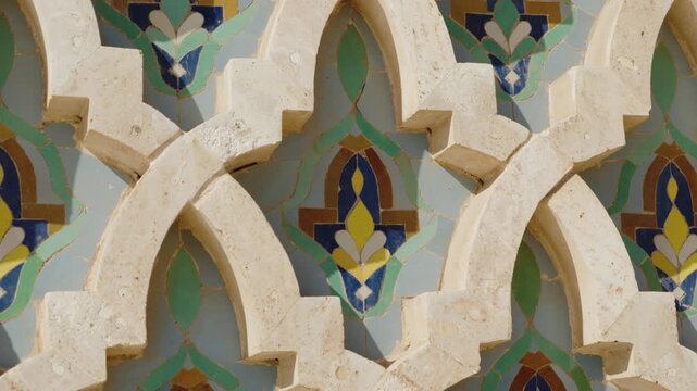 Close up of intricate Moroccan tile work and stone carvings. This detailed view showcases the craftsmanship of the Hassan II Mosque in Casablanca, Morocco. The beautiful patterns