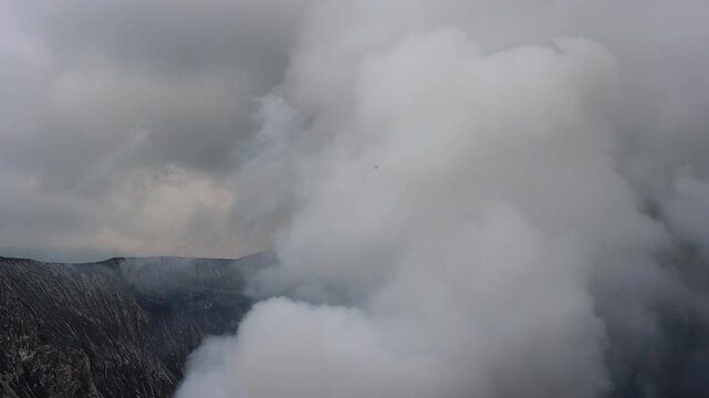 The interior of Mount Bromo volcano, where thick white volcanic steam billows upward from active vents within the crater in East Java, Indonesia