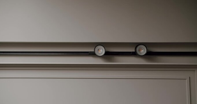 Modern ceiling light fixtures mounted on a minimalist interior. Simple and elegant lighting for contemporary home aesthetics. Modern Minimalist Track Lighting Fixture on Textured Wall Interior Design