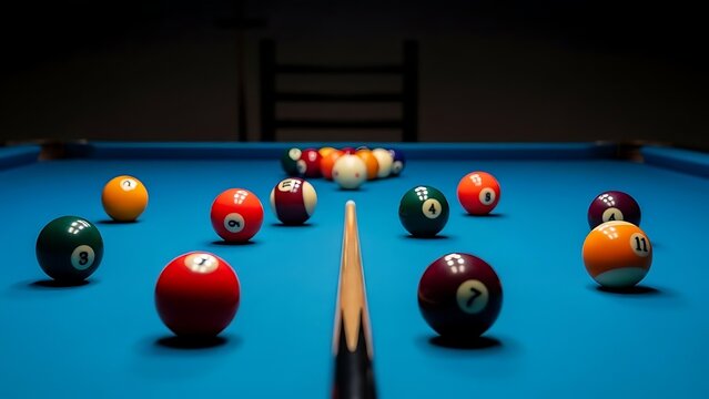 Blue felt pool table with scattered billiard balls at night.