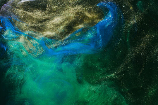 Abstract colorful green smoke on black background. Moving flow of paints, fluid liquid art, space sky