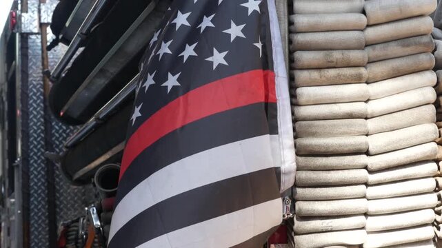 Red thin line black american flag on firefighter truck. Hose of firetruck and fire fighters symbol in New York, United States. 911 remembrance, fire department engine vehicle. September 11 Patriot Day