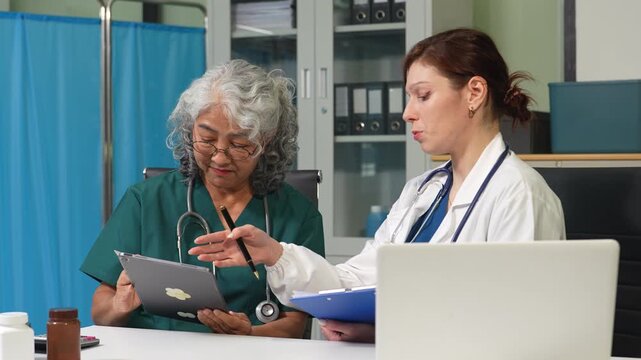 Medical team working with a tablet and Laptop computer search for medical information at the hospital office.