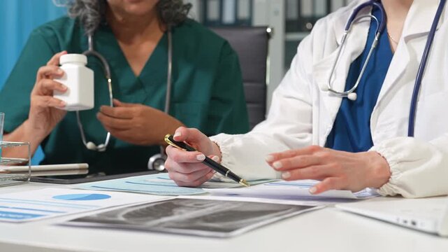 Medical team working with a tablet and Laptop computer search for medical information at the hospital office.