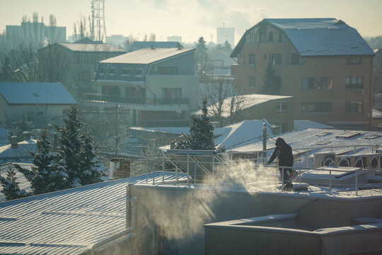 man clearing snow from the terrace of a house.