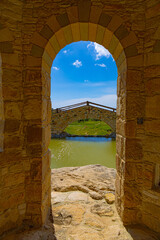 Obraz premium Looking through stone arch on bridge in Old stone monastery of Saint Georgios the Spilaion near city Limassol, Cyprus