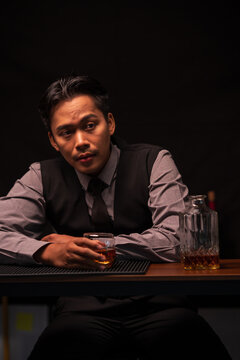 Bartender Holding Out a Glass of Premium Whiskey to Customer