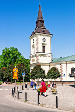 Sunny town square with a church and people walking on the pavement a summer day