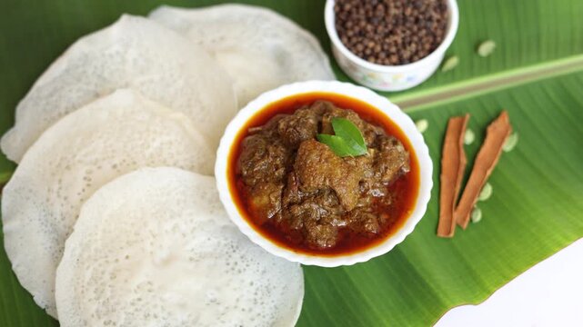 Appam Idiyappam rice dosa a popular traditional  cooked Kerala breakfast dish with hot and spicy duck roast curry on a houseboat Alleppey India. South Indian food. noolputtu Sri lankan