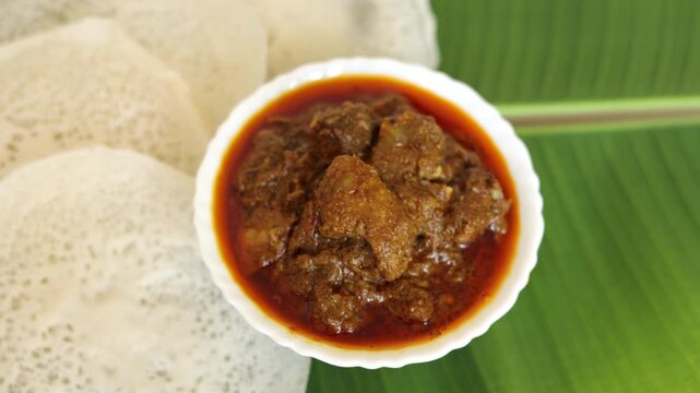 Appam Idiyappam rice dosa a popular traditional  cooked Kerala breakfast dish with hot and spicy duck roast curry on a houseboat Alleppey India. South Indian food. noolputtu Sri lankan