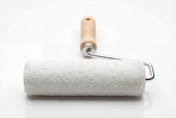 Fototapeta premium Unused white paint roller with a wooden handle isolated on a seamless white surface