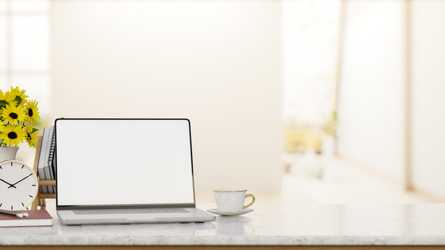 White screen laptop and coffee with clock and sunflower vase on marble counter table in bright room.