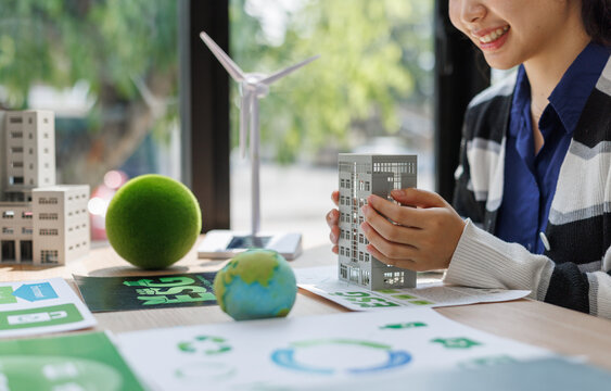 Person holding building model planning sustainable urban development