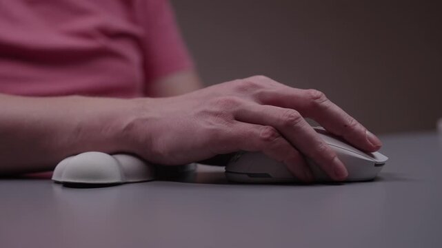 Ergonomic wrist rest preventing carpal tunnel syndrome while using wireless computer mouse on desk for healthier work habits and repetitive strain injury prevention, close-up. Shooting in slow motion.