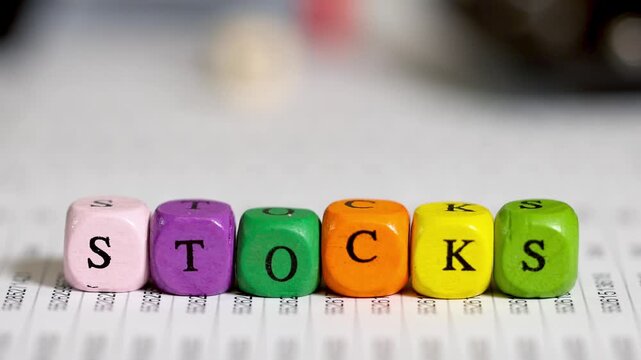 Colorful wooden blocks spelling stocks on a financial document