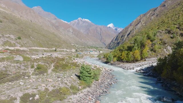 Aerial Drone shot revealing the winding Baspa River and pine forests of Himachal Pradesh.