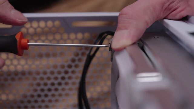 Technician hands using screwdriver to tighten screw, assembling or repairing personal computer, focusing on hardware installation and maintenance. Concept of computer hardware, repairing, upgrade.