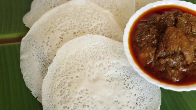 Appam Idiyappam rice dosa a popular traditional  cooked Kerala breakfast dish with hot and spicy duck roast curry on a houseboat Alleppey India. South Indian food. noolputtu Sri lankan
