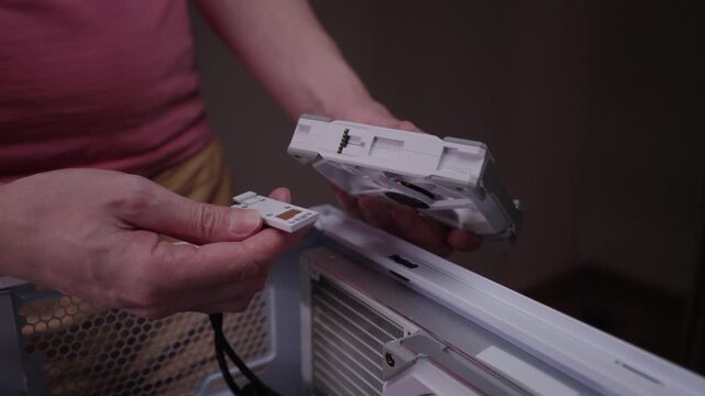 Skilled technician hands connecting daisy chained fans, preparing to install cooling system on radiator for custom built high performance gaming pc. Concept of desktop PC maintenance and service.