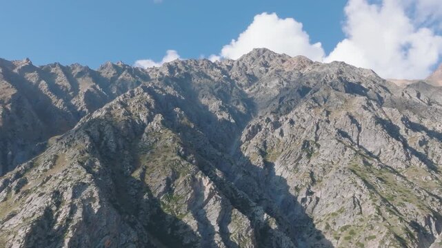 Cinematic drone orbit around steep, rugged mountain ridges in Kinnaur Valley, Himalayas.