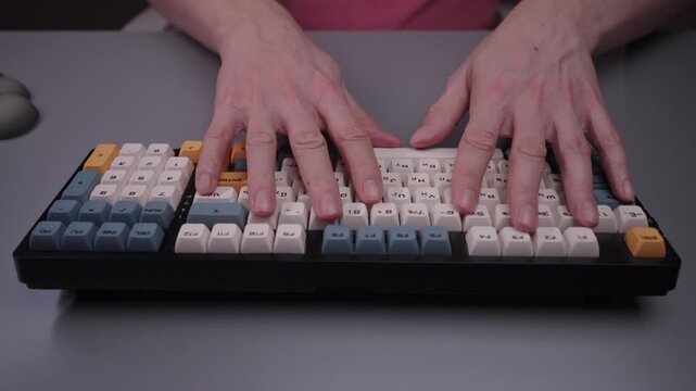Person typing on ergonomic keyboard with wrist rest for comfort and carpal tunnel syndrome prevention, showing importance of workplace posture and health, close-up, cropped shot, slow mtoion.