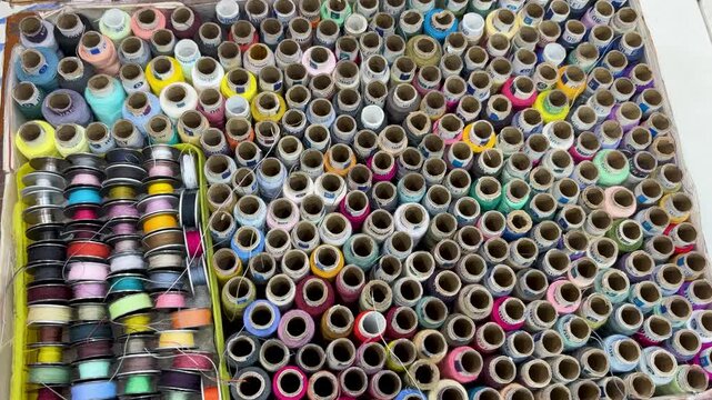 large collection of colorful sewing thread spools neatly arranged in box tailoring accessories