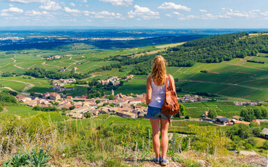 Fototapeta premium Young Woman Overlooking Scenic Burgundy Vineyards and Village Landscape - Wine Region France