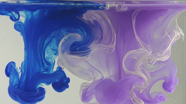 Vibrant blue and purple liquids swirl and mix in a mesmerizing dance underwater, creating intricate patterns and shapes.
