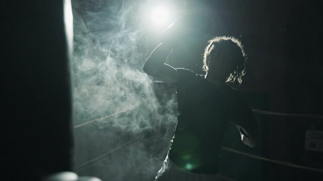 Box and kickboxing workout, motivation african sportsman fighting with punch bag . Sport and energy, self-defense class, young athlete developing endurance and tensing muscles of body, be strong