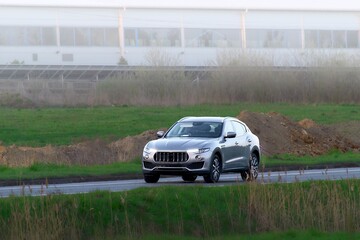 Fototapeta premium Luxury SUV car passing construction site