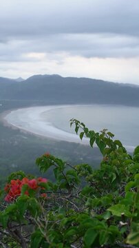 Vertical Background of Scenic landscape of a coastline bay with turquoise water under cloudy sky, Pacitan, Indonesia