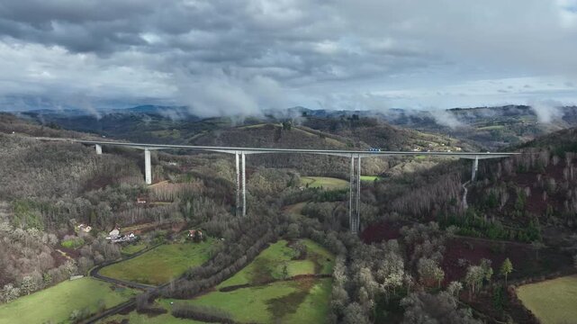 Aerial view of Viaduc du Pays de Tulle with vehicles on the long concrete viaduct over rolling hills and forests in Limousin