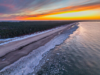 Beautiful sunset over the frozen Baltic Sea beach in Jantar, Poland