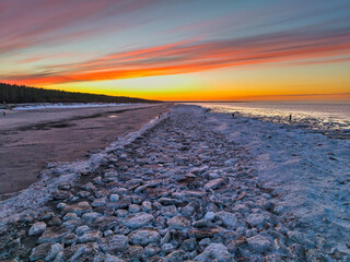 Beautiful sunset over the frozen Baltic Sea beach in Jantar, Poland