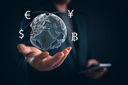 Businessman hand holding globe currency symbols dollar euro yen baht international exchange global finance investment business connectivity digital money transfer concept.