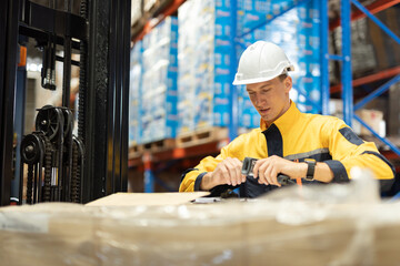 Man warehouse worker scanning barcode on package using handheld device, inventory control and stock management in logistics warehouse, industrial operation, supply chain and distribution concept © eakgrungenerd