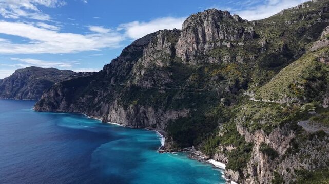 Aerial view of the rugged coastline, where turquoise waters meet the dramatic cliffs and winding roads near Via Nastro Azzurro, Vico Equense, Campania, Italy.