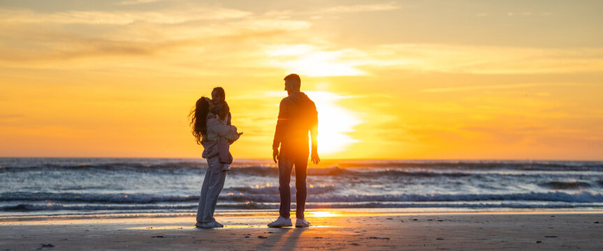 Family enjoying beach sunset together during vacation