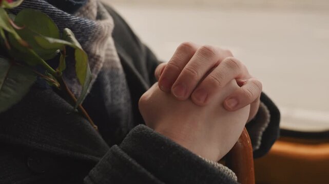 Quiet moment during daily journey. Silent pause captured with clasped palms and thoughtful expression. An individual is holding handle quietly during peaceful afternoon travel reflection