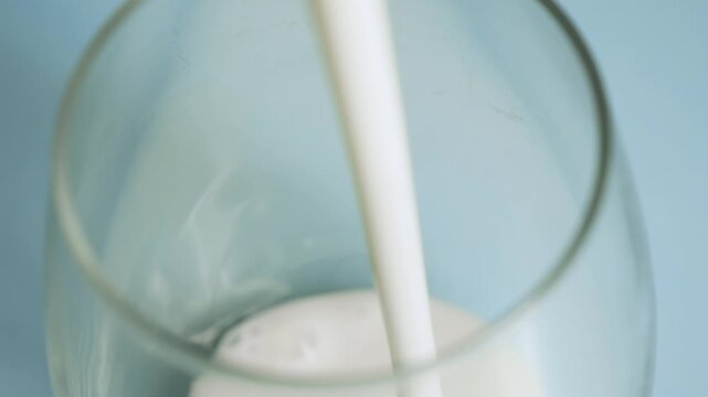 Kefir being poured into a glass healthy fermented milk drink flowing probiotic dairy beverage concept. High quality 4k footage