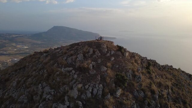 Drohnenaufnahme eines Berges mit Klippen und Meer in Sizilien
