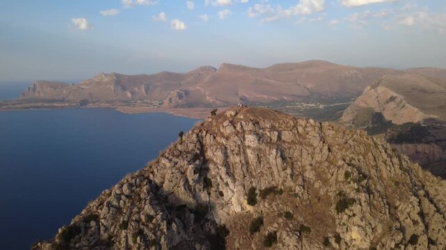Drohnenaufnahme eines Berges mit Klippen und Meer in Sizilien