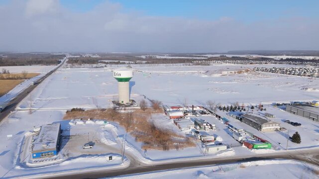 Town Of Erin Water Tower With New Housing Community During Ontario House Shortage. Orbiting Drone Shot.