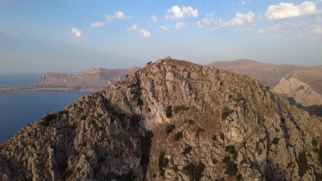 Drohnenaufnahme eines Berges mit Klippen und Meer in Sizilien