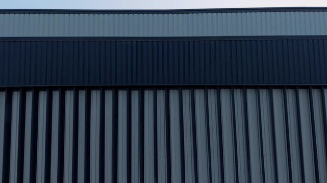 Close up aerial shot of blue and gray corrugated metal siding on a large production facility or engineering warehouse.