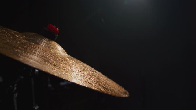 Drum player hits cymbals of drum set. Drummer playing the drums with drumsticks. Drum player hits the cymbals of the drum set powerfully during the rock show on a stage under strobe flashes close up