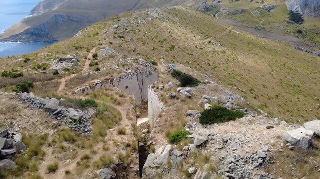 Drohnenaufnahme eines Berges mit Klippen und Meer in Sizilien